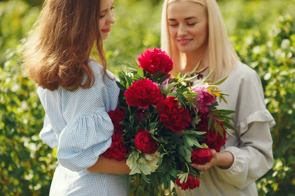 Women in elegant clothes standing in a summer field — Stock Photo, Image