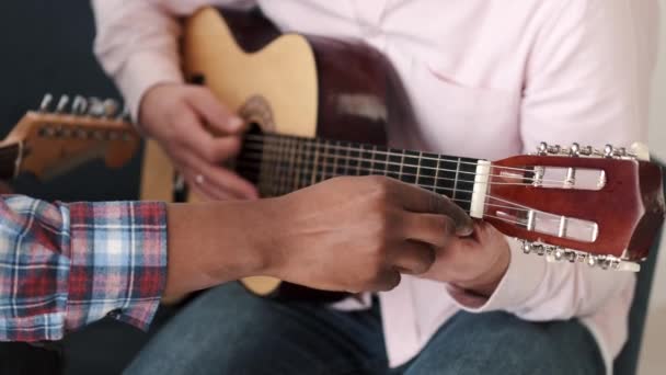Dos amigos aprenden a tocar la guitarra acústica — Vídeos de Stock