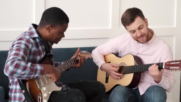 Två vänner lär sig att spela akustisk gitarr — Stockvideo