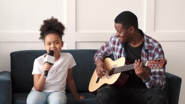 Afrikaanse vader speelt gitaar, dochter zingt — Stockvideo