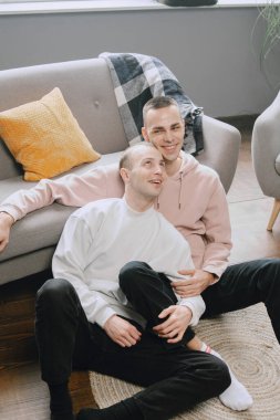 Memlekette birlikte televizyon izleyen mutlu eşcinsel çift.