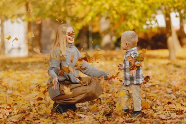 Anne ve küçük oğlu sonbahar tarlasında oynuyorlar.