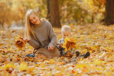 Anne ve küçük oğlu sonbahar tarlasında oynuyorlar.