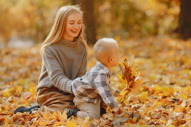 Anne ve küçük oğlu sonbahar tarlasında oynuyorlar.