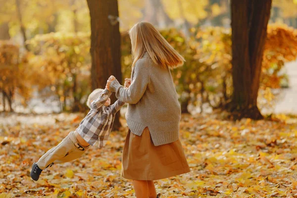 Mutter mit kleinem Sohn spielt auf einem Feld im Herbst — Stockfoto