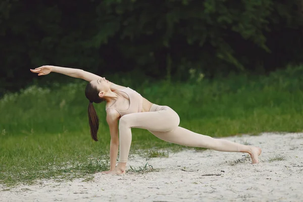 Frau praktiziert fortgeschrittenes Yoga am Strand — Stockfoto