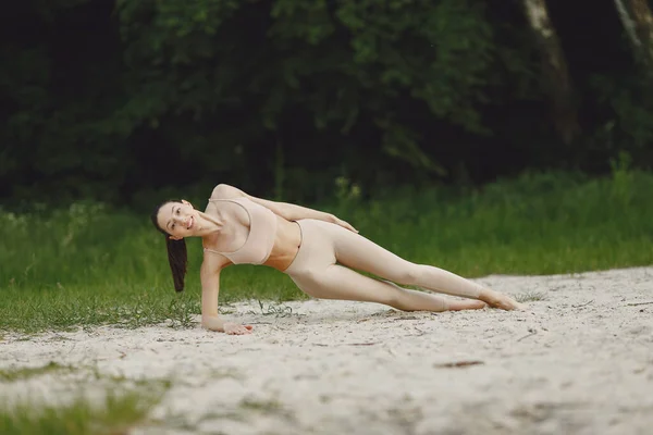 Mulher praticando ioga avançado em uma praia de verão — Fotografia de Stock