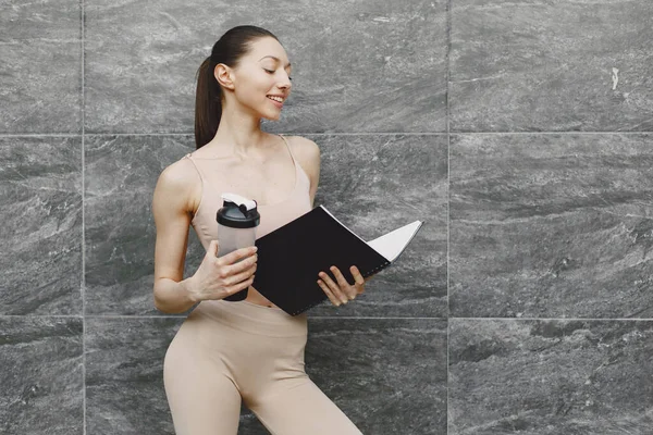 Femme pratiquant le yoga avancé contre un mur urbain sombre — Photo