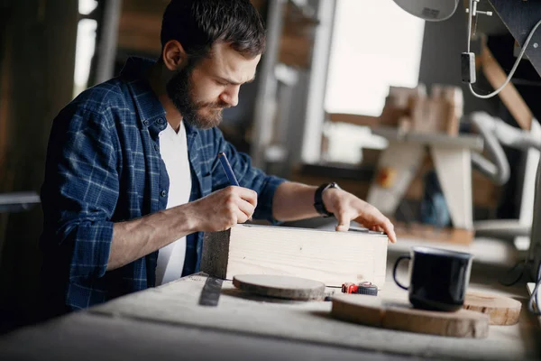 Man in de werkplaats met een hout — Stockfoto