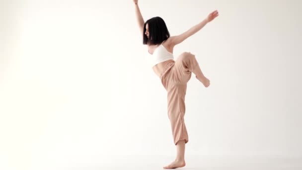 Mujer en traje beige bailando contemp sobre fondo blanco — Vídeos de Stock