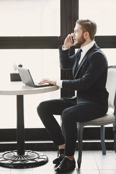 Homme assis avec ordinateur portable dans un café — Photo