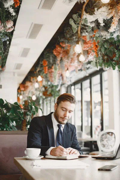 Homme assis avec ordinateur portable dans un café — Photo