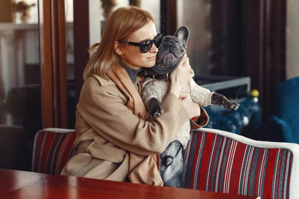 Elegant woman in a brown coat with black bulldog — Stock Photo, Image