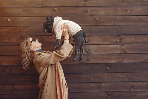 Elegant woman in a brown coat with black bulldog — Stockfoto