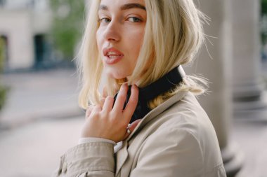 Sarışın, yaz şehrinde müzik dinliyor.