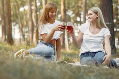 Piknikte oturup şarap içen kızlar