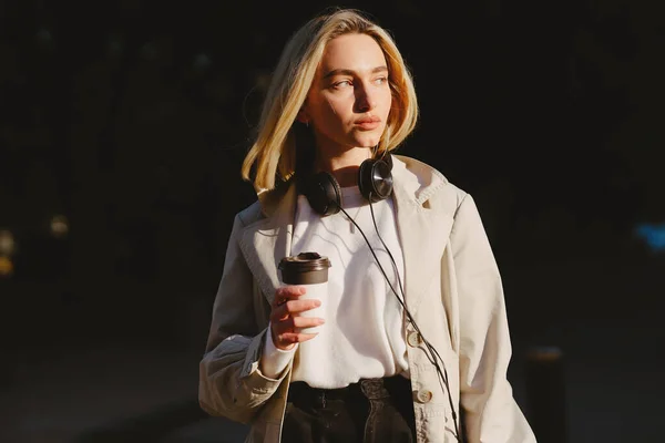 Blonde walks in summer city with cup of coffee — Stock Photo, Image