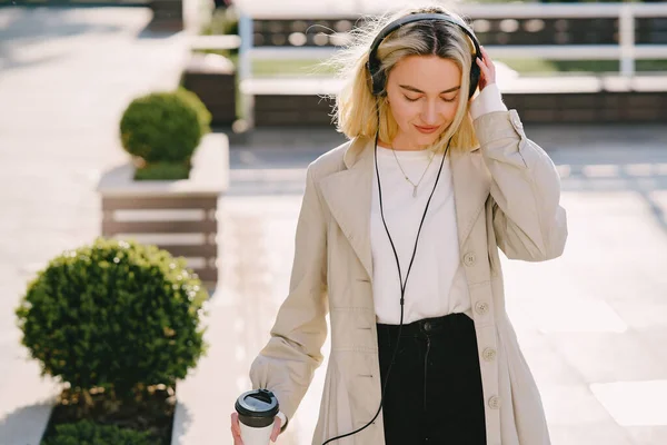 Blonde walks in summer city with cup of coffee — Stock Photo, Image