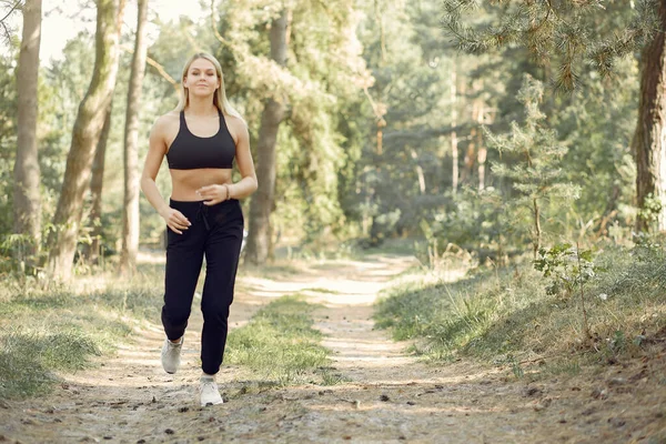 Beautiful woman runs in a summer park — Stock Photo, Image