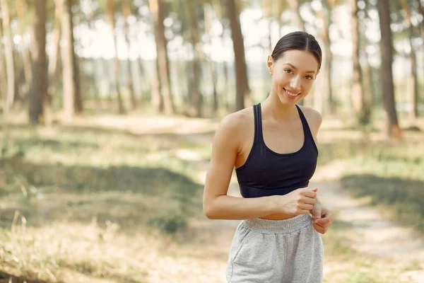 Mulher bonita corre em um parque de verão — Fotografia de Stock