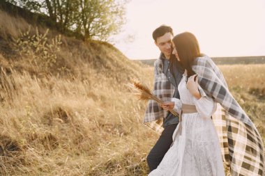 Gün batımında buğday tarlasında aşık mutlu çift