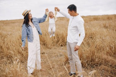 Sonbahar tarlasında oynayan sevimli bir aile.