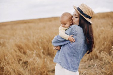 Anne ve kızı sonbahar tarlasında oynuyorlar.