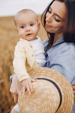 Anne ve kızı sonbahar tarlasında oynuyorlar.