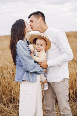 Sonbahar tarlasında oynayan sevimli bir aile.