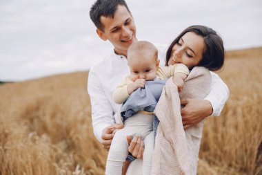 Sonbahar tarlasında oynayan sevimli bir aile.