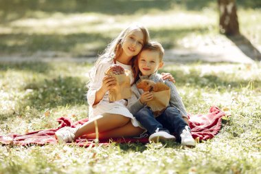 Parkta elinde ekmekle oturan sevimli küçük çocuklar.