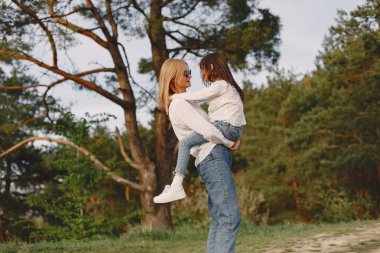 Kızıyla birlikte yaz ormanında zarif bir anne.