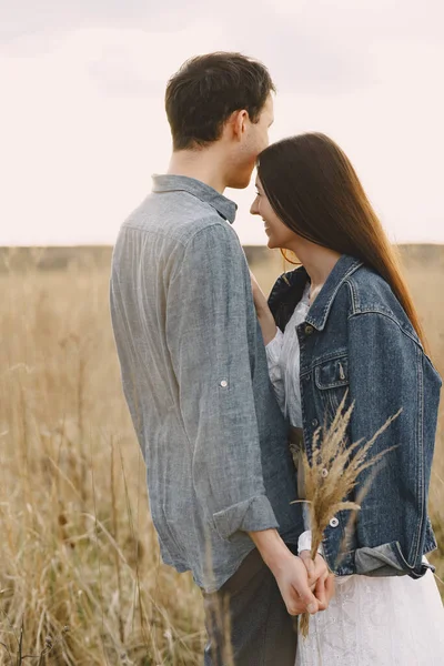 Gelukkig paar in liefde in tarweveld bij zonsondergang — Stockfoto