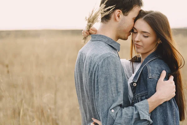 Feliz casal apaixonado no campo de trigo ao pôr-do-sol — Fotografia de Stock