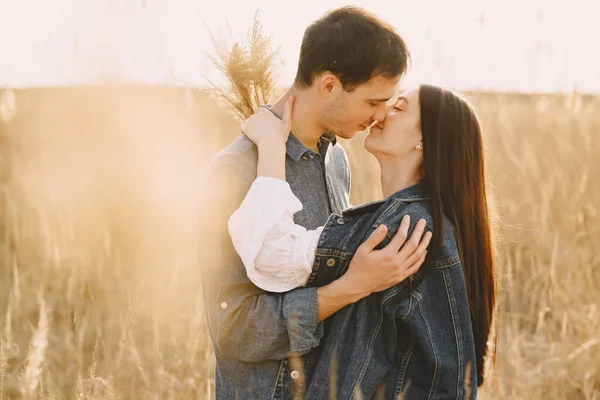 Lyckligt par kär i vetefält vid solnedgången — Stockfoto