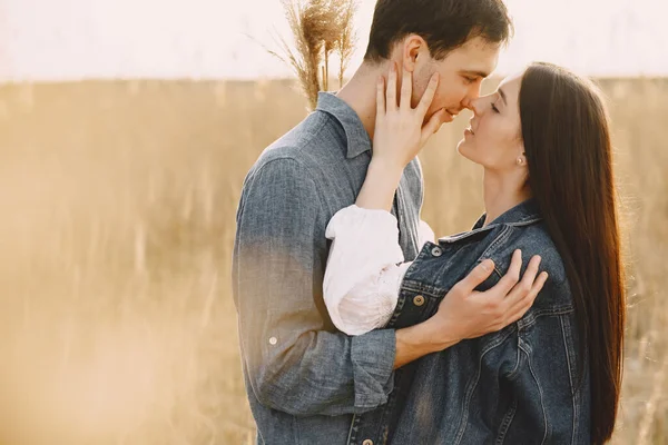 Feliz casal apaixonado no campo de trigo ao pôr-do-sol — Fotografia de Stock