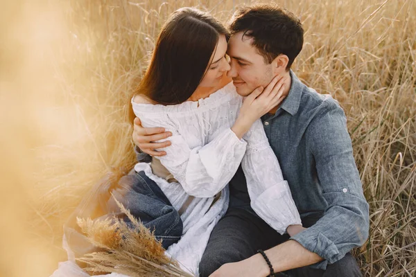 Gelukkig paar in liefde in tarweveld bij zonsondergang — Stockfoto