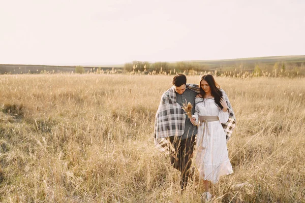 Gelukkig paar in liefde in tarweveld bij zonsondergang — Stockfoto