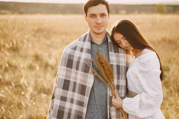 Pareja feliz enamorada en el campo de trigo al atardecer — Foto de Stock