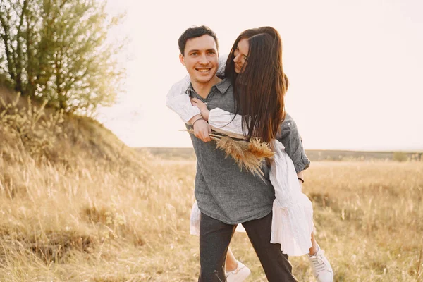 Gelukkig paar in liefde in tarweveld bij zonsondergang — Stockfoto