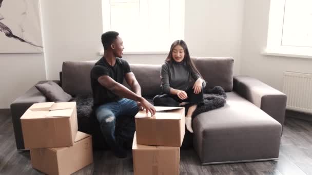 Пара распаковывающих коробок в их новом доме — стоковое видео