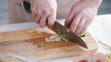 Evdeki mutfakta birlikte yemek pişiren mutlu Asyalı genç çiftin portresi.