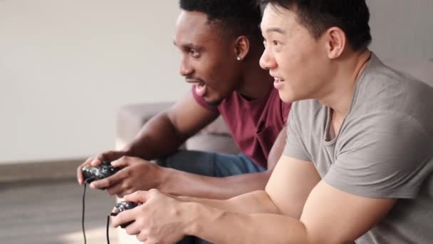 Aufgeregte Freunde, die zu Hause Videospiele spielen — Stockvideo