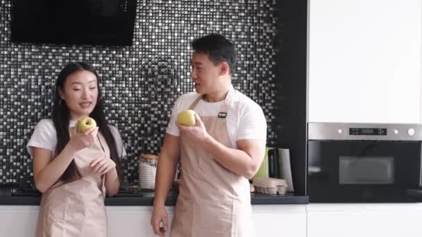 Retrato de feliz jovem casal asiático cozinhar juntos na cozinha em casa — Vídeo de Stock
