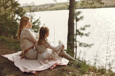 Suyun kenarında çocukları olan zarif bir anne.