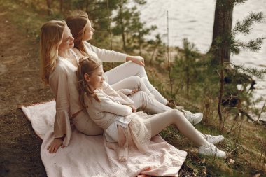 Suyun kenarında çocukları olan zarif bir anne.