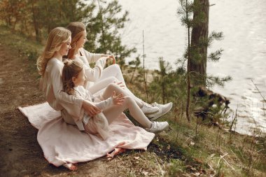 Suyun kenarında çocukları olan zarif bir anne.