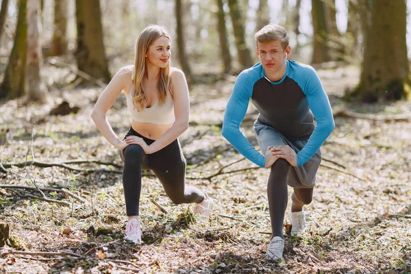 Treinamento de casais esportivos em uma floresta de verão — Fotografia de Stock