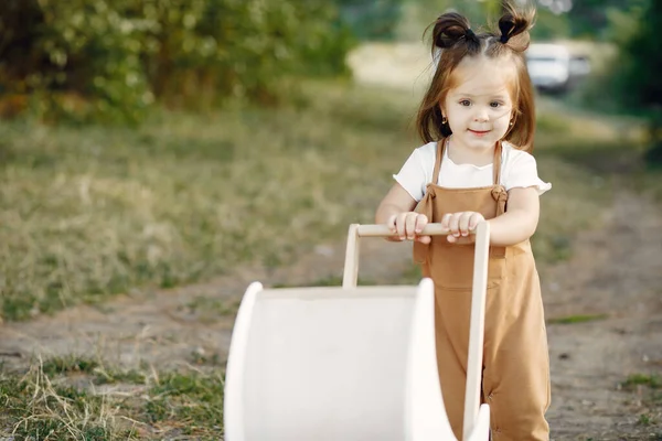 可爱的小女孩在公园里和白色的马车玩耍 — 图库照片