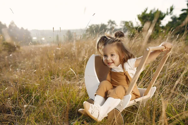 Bonita menina brincando em um parque com carruagem branca — Fotografia de Stock